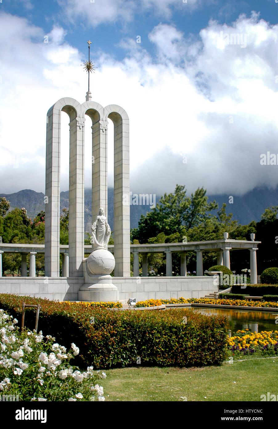 Hugenotten-Denkmal mit Wolken und Franschhoek Pass Bergen im Hintergrund, Franschhoek, Südafrika Stockfoto