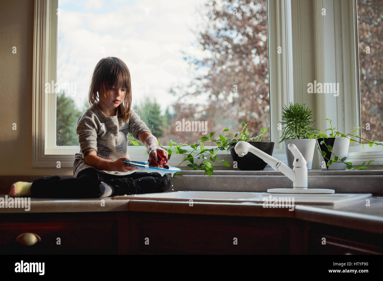 Mädchen beim Abwasch in der Küchenspüle Stockfoto