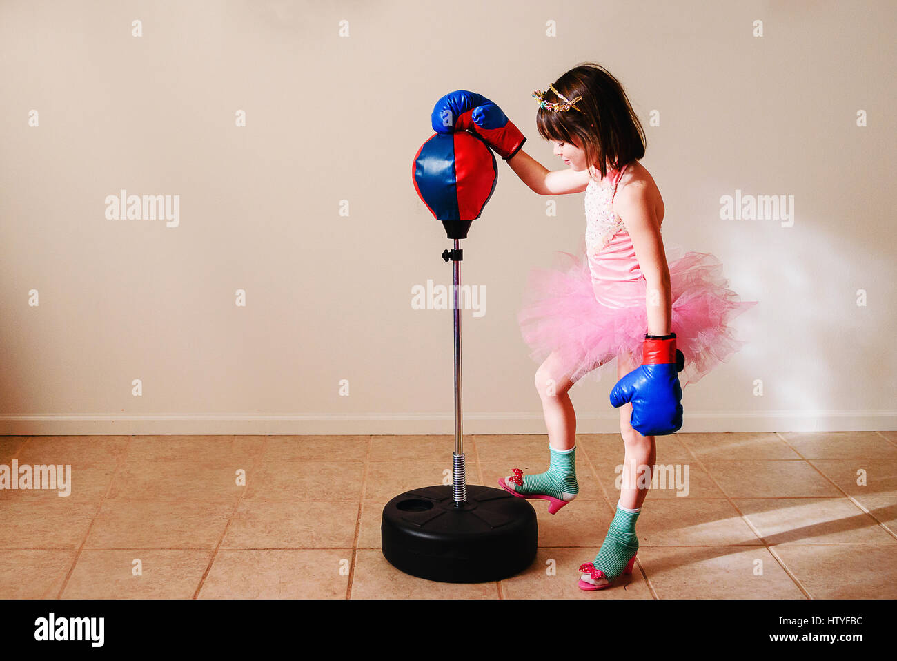 Mädchen im rosa Tutu und Schuhen mit hohen Absätzen zu Boxen lernen Stockfoto