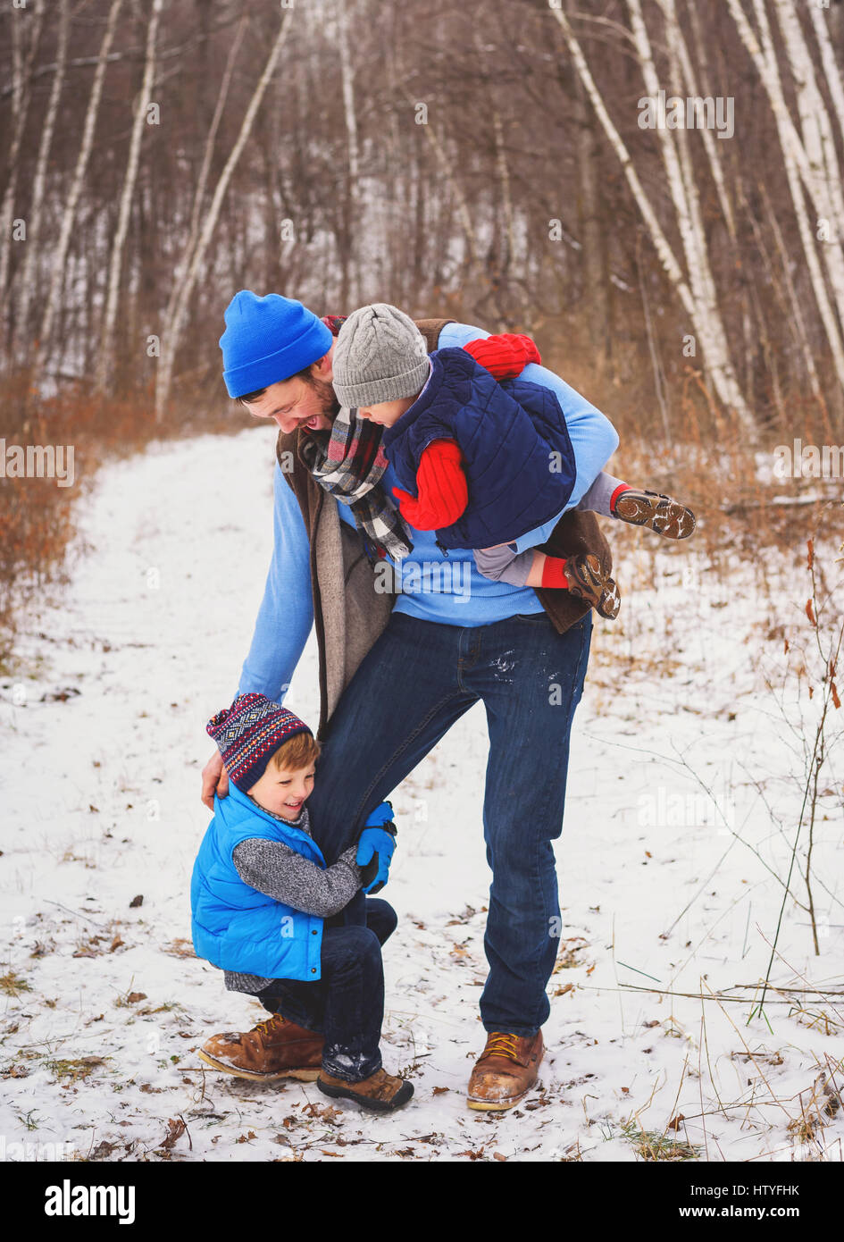 Vater zweier Söhne im Schnee spielen Stockfoto