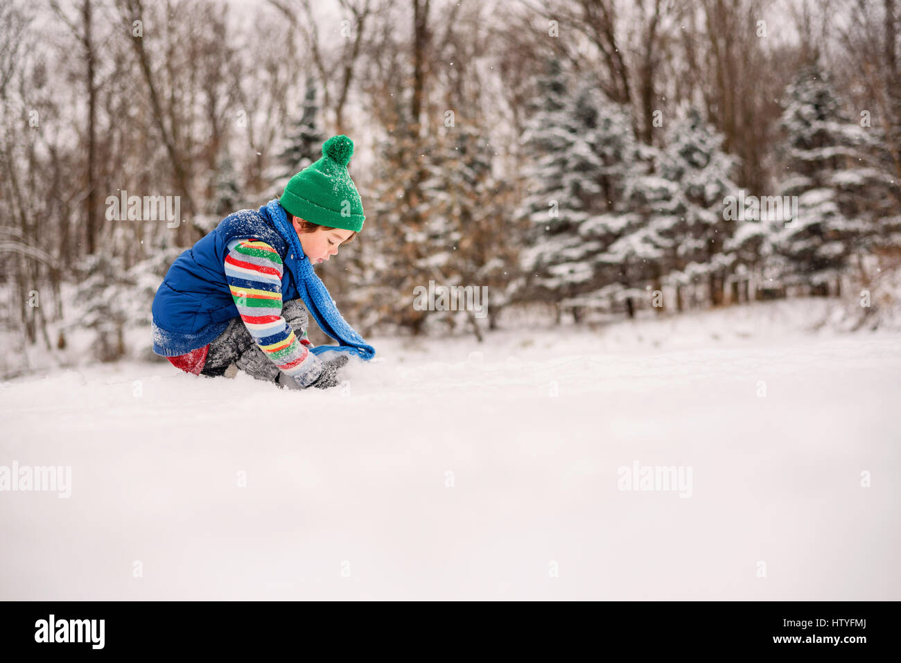 Jungen spielen im Schnee Stockfoto