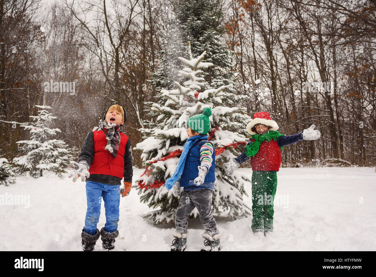 Drei Kinder spielen im Schnee Stockfoto