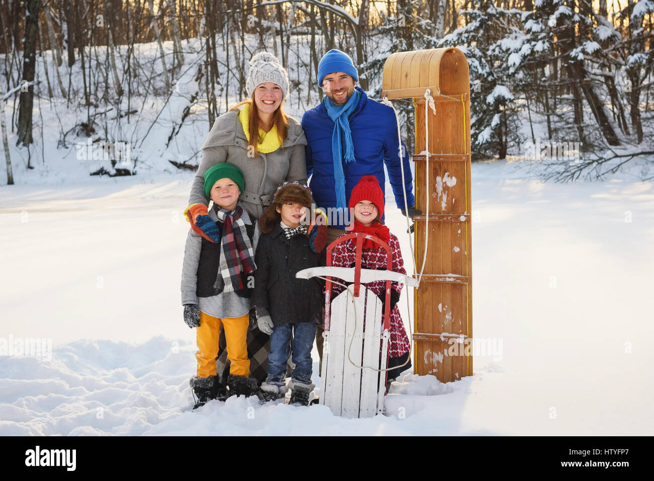 Porträt einer Familie stehen im Schnee mit dem Schlitten Stockfoto
