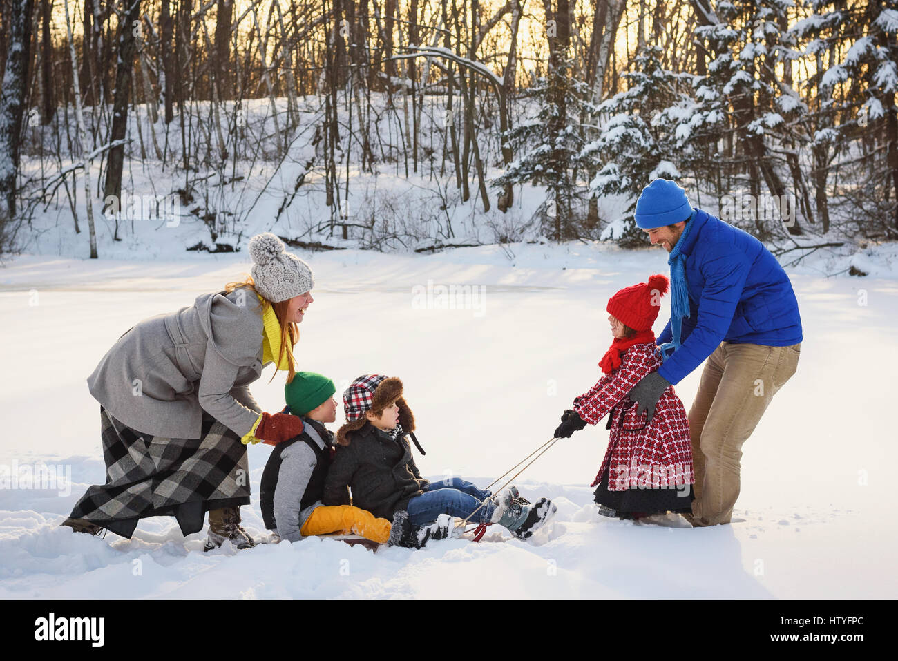 Familie, spielen im Schnee mit dem Schlitten Stockfoto