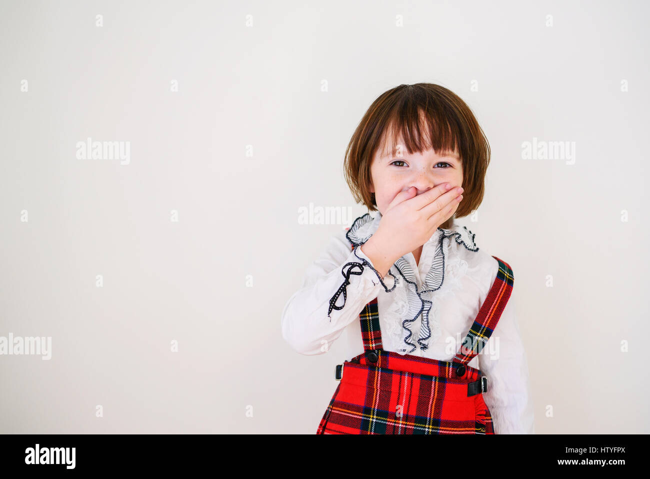 Porträt eines Mädchens kichernd mit der Hand vor den Mund Stockfoto