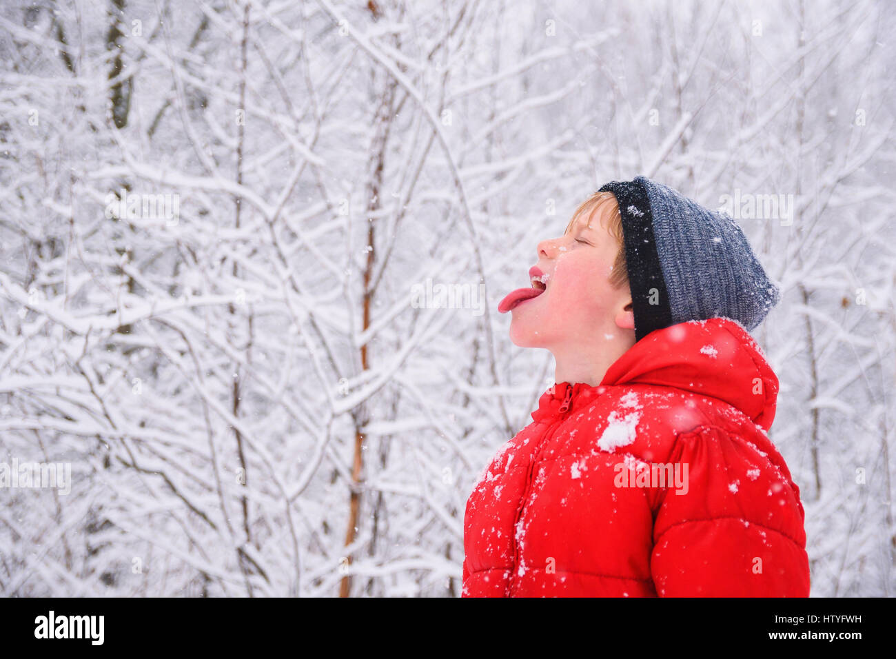 Junge Schneeflocken in den Mund zu fangen Stockfoto