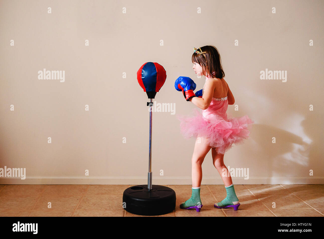 Mädchen im rosa Tutu und Schuhen mit hohen Absätzen zu Boxen lernen Stockfoto