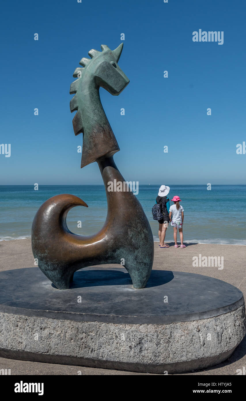 Mutter und Tochter stehen auf Blick auf das blaue Meer hinter The Good Fortune Unicorn Skulptur von Aníbal Riebeling Puerto Vallarta Malecon. Stockfoto