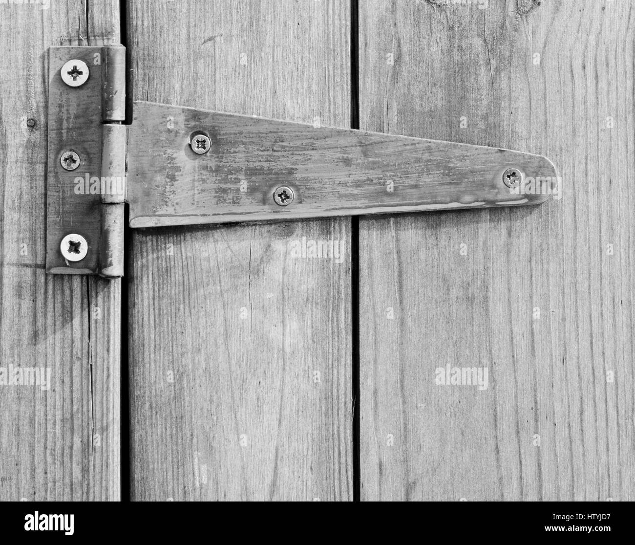 Nahaufnahme von geschraubten Scharnier auf Holztür. Stockfoto