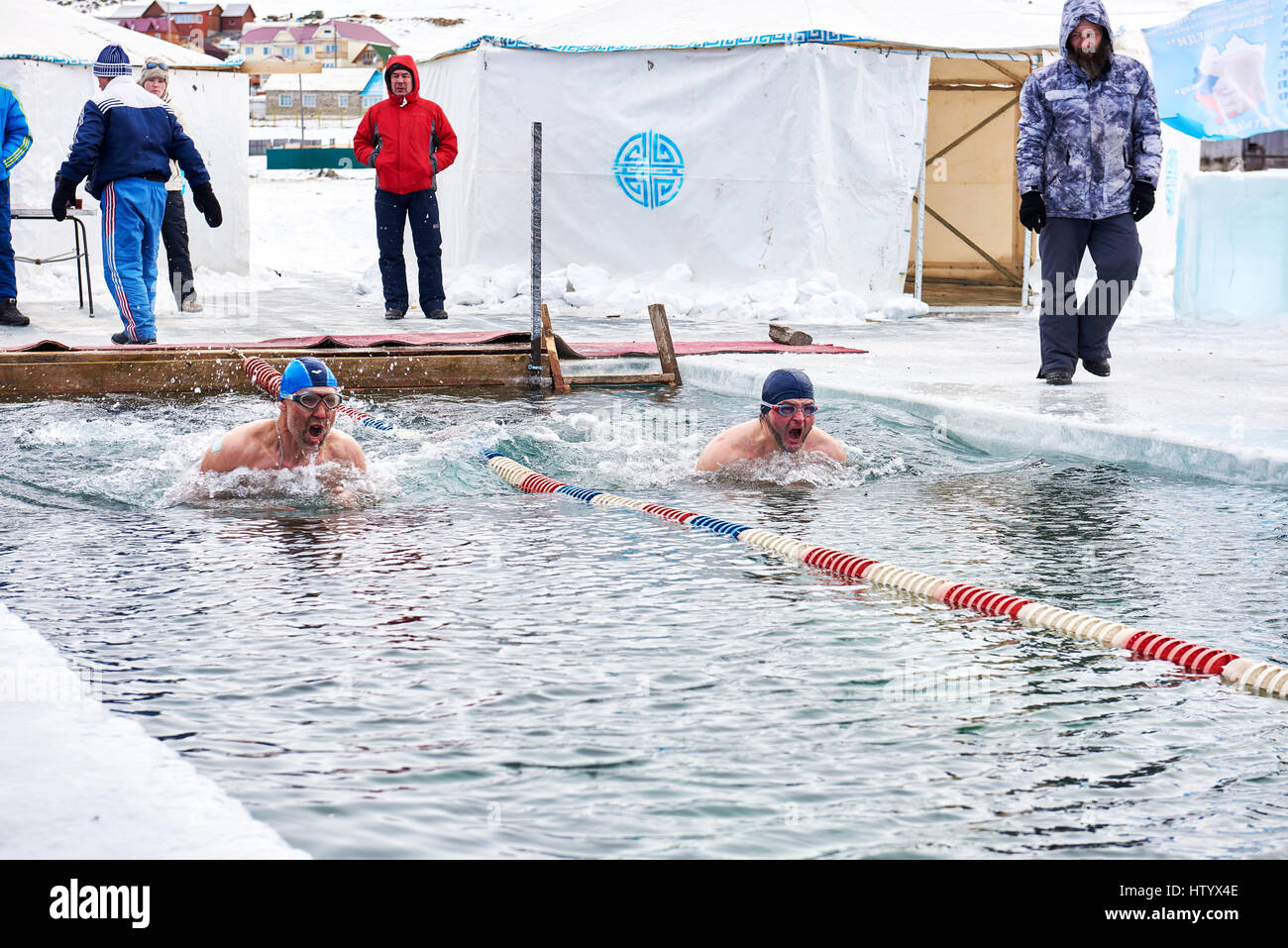 SAHYURTA, Gebiet IRKUTSK, Russland - März 11.2017: Cup des Baikalsees. Winter-Schwimmwettkampf. Zwei Schwimmer machen schnellen Atem vor dem Tauchen Stockfoto