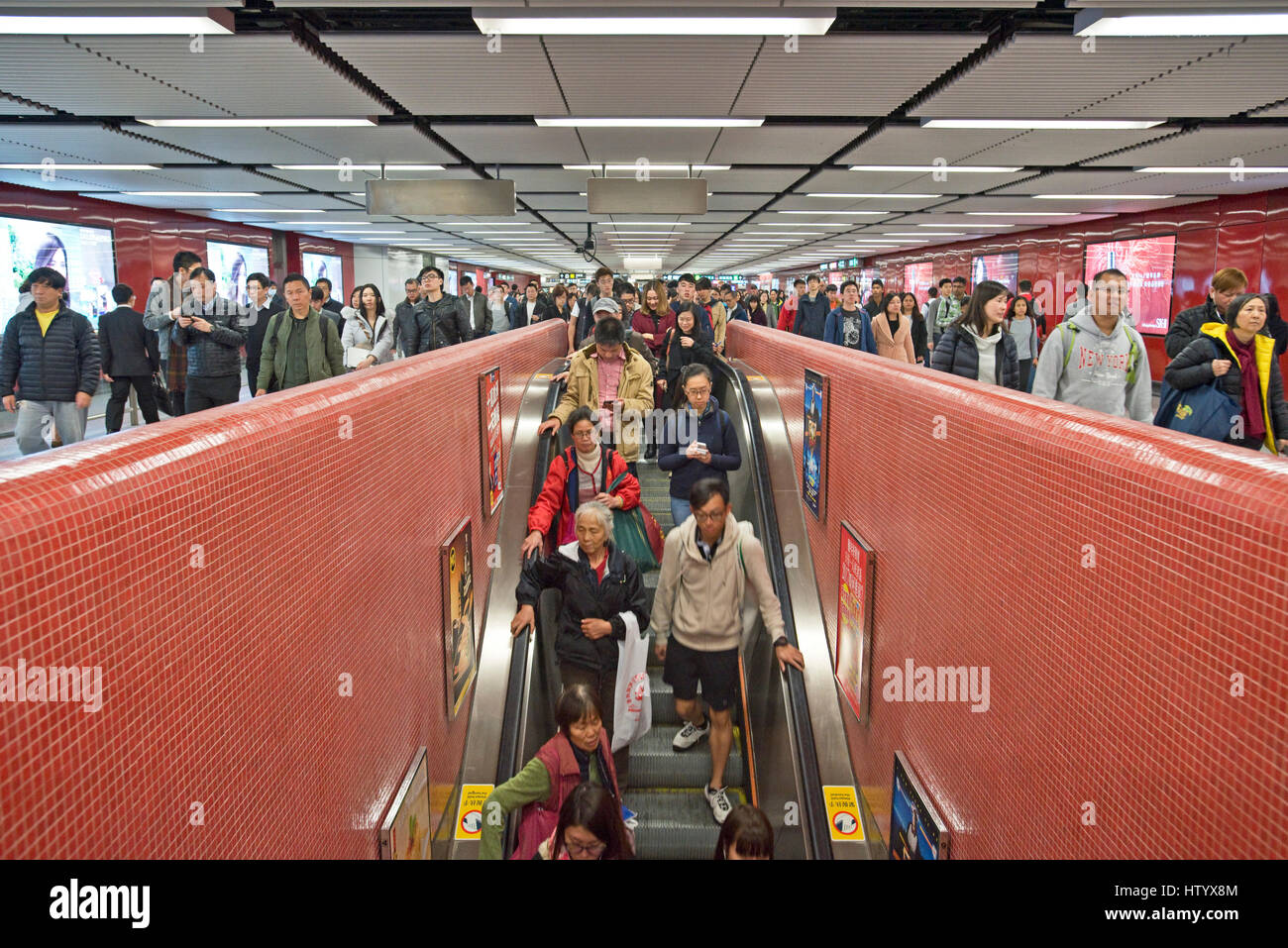 Massen von Pendler und Menschen vor Ort auf der Rolltreppe des Systems der MTR in Hong Kong. Stockfoto