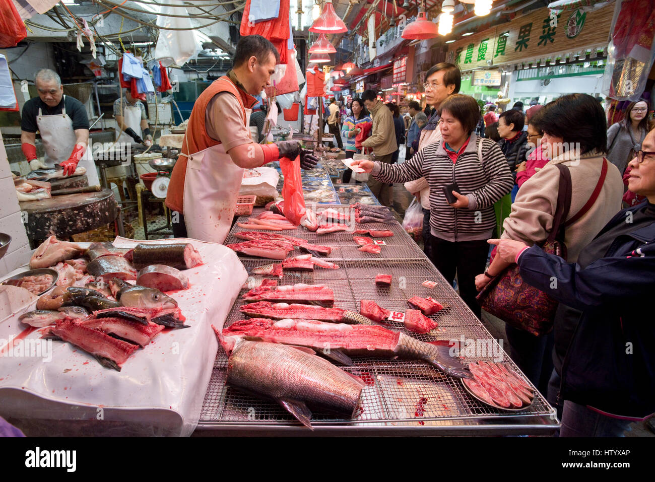 Lokale asiatische chinesische Leute kaufen frischen Fisch von den Geschäften in nassen Markt Wan Chai, Hong Kong. Stockfoto