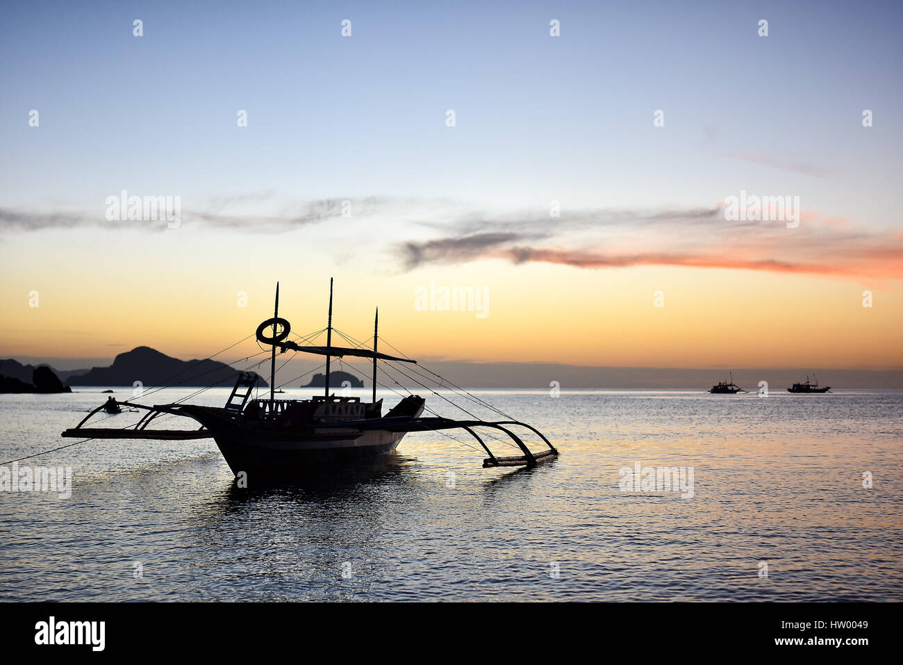 Filipino-traditionellen Stil Pumpe Boot schwimmend in einem ruhigen Meer bei Sonnenuntergang Stockfoto