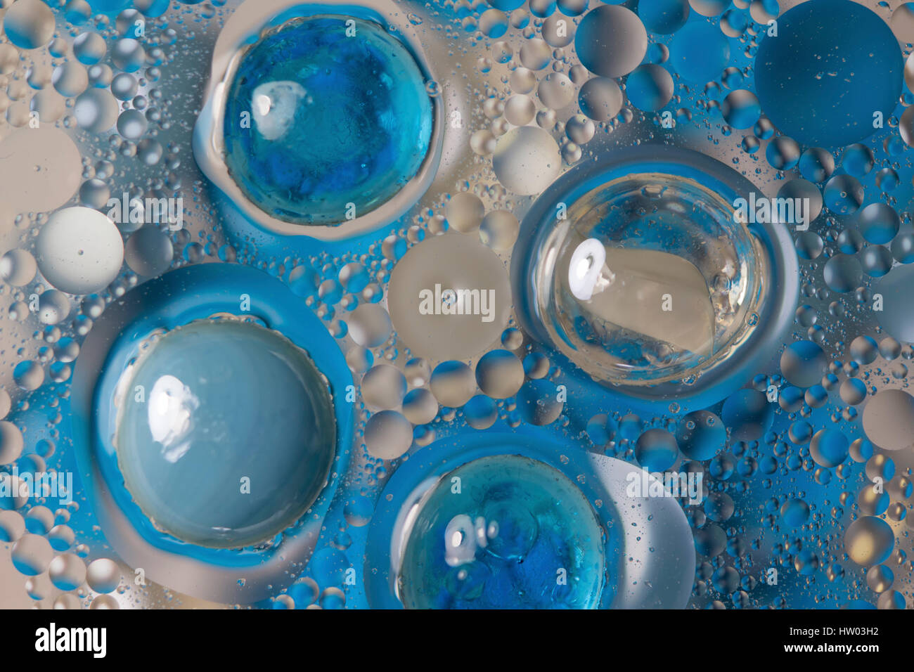 Blaue Perlen und Blasen in das ölhaltige Wasser Stockfoto
