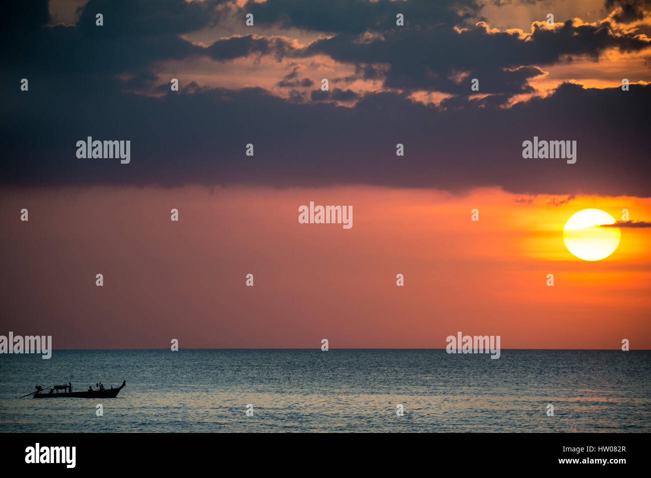 Großer Sonnenterrasse und ein Fischerboot bei Sonnenuntergang in Phuket - Thailand Stockfoto