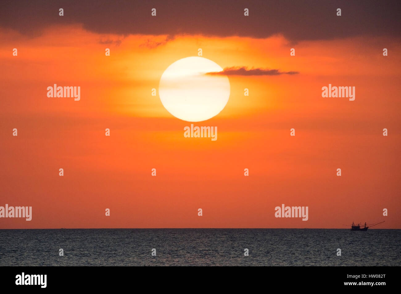 Großer Sonnenterrasse und ein Fischerboot bei Sonnenuntergang in Phuket - Thailand Stockfoto