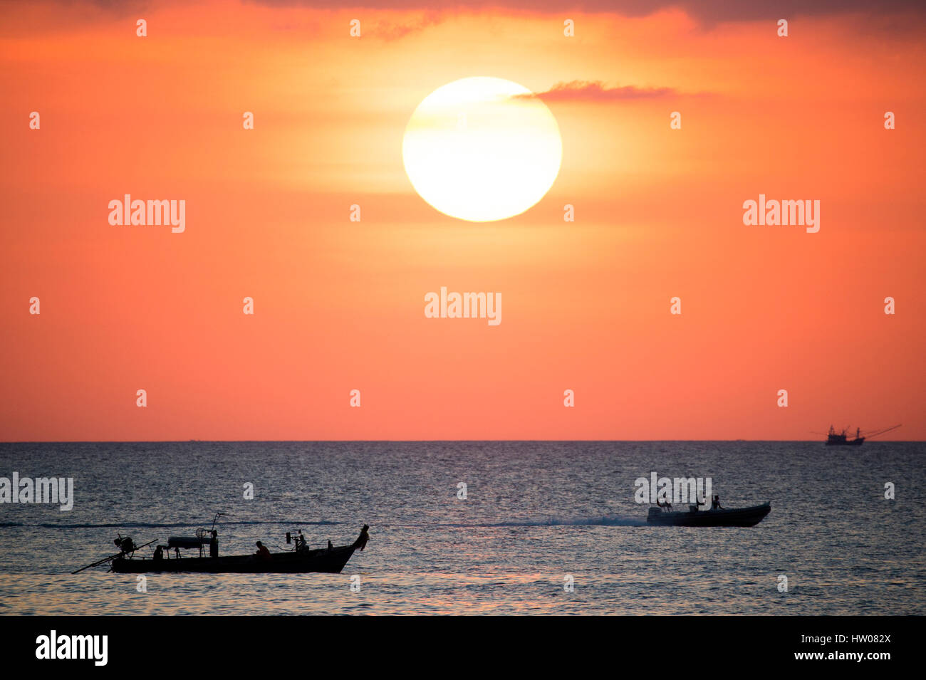 Großer Sonnenterrasse und ein Fischerboot bei Sonnenuntergang in Phuket - Thailand Stockfoto