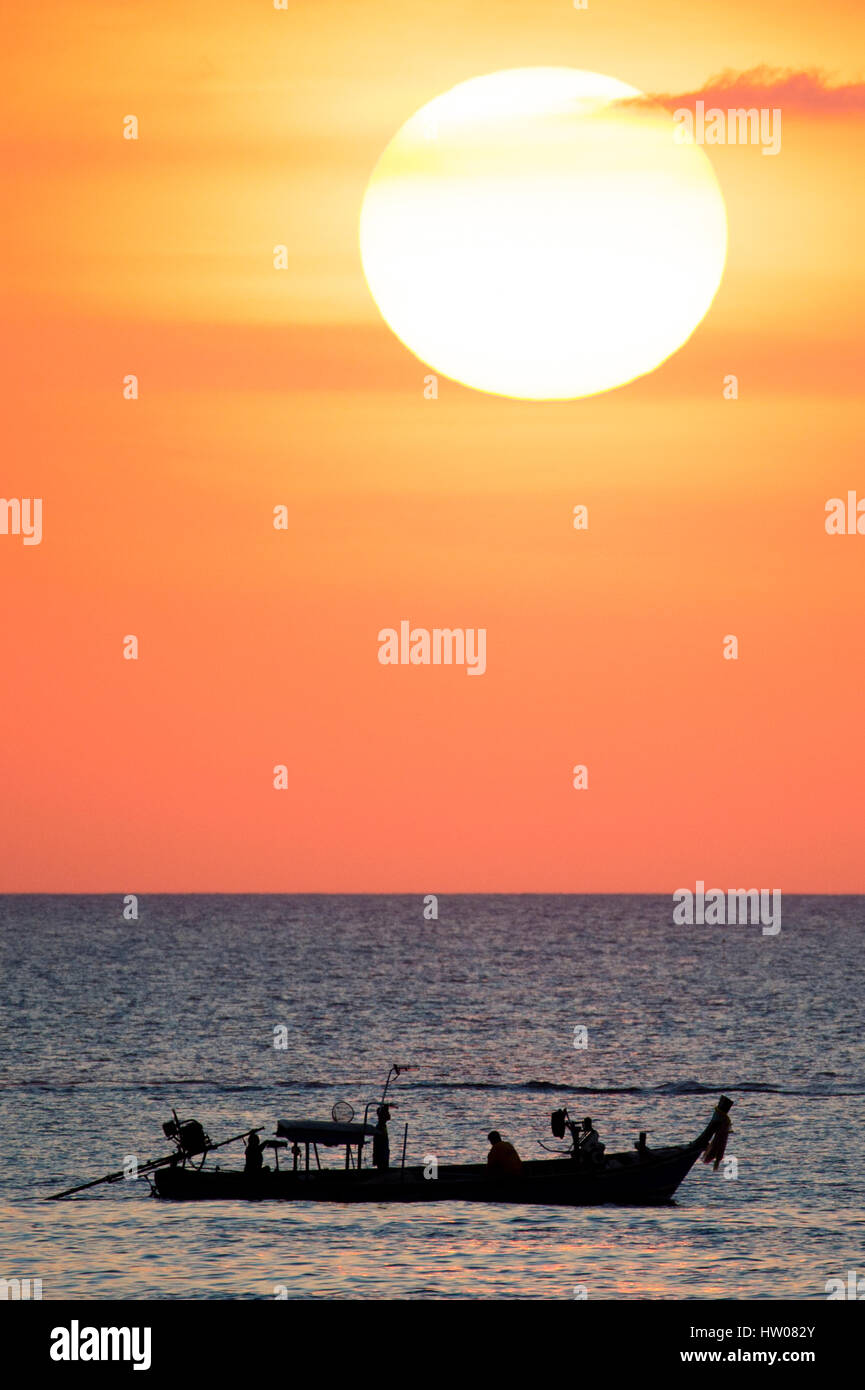 Großer Sonnenterrasse und ein Fischerboot bei Sonnenuntergang in Phuket - Thailand Stockfoto
