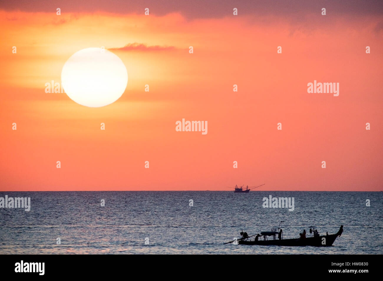 Großer Sonnenterrasse und ein Fischerboot bei Sonnenuntergang in Phuket - Thailand Stockfoto