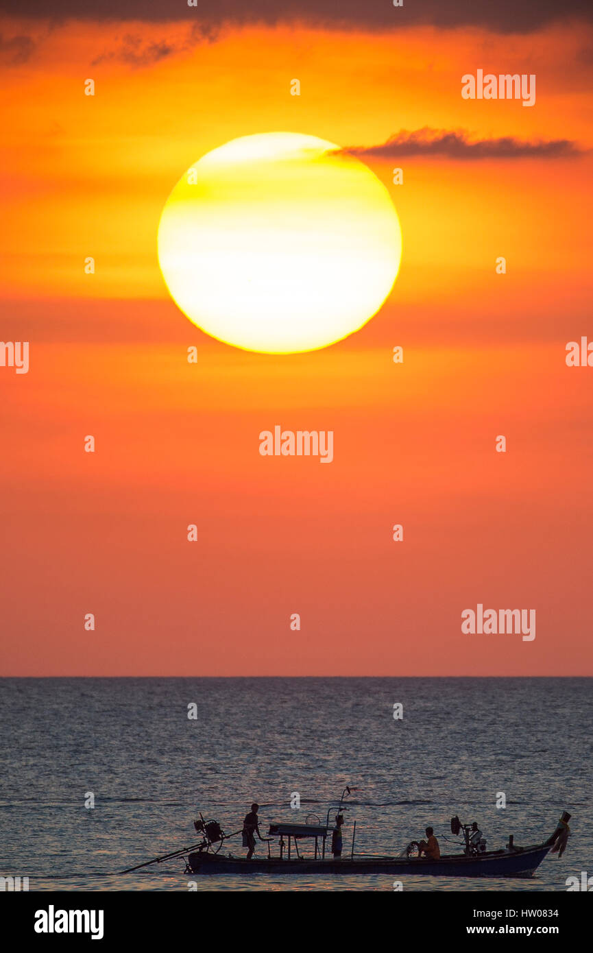 Großer Sonnenterrasse und ein Fischerboot bei Sonnenuntergang in Phuket - Thailand Stockfoto