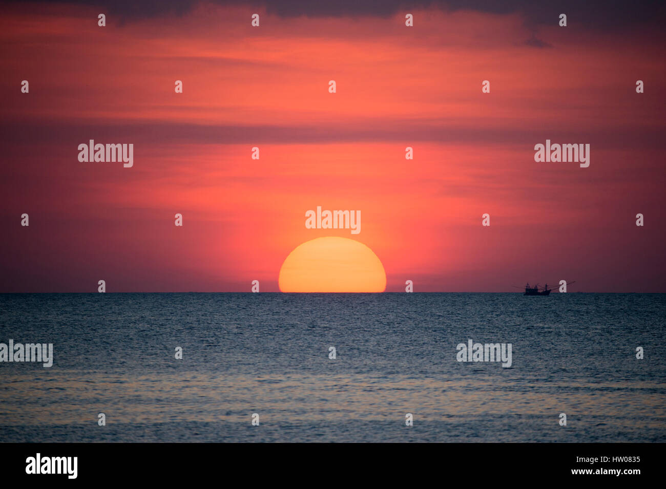 Großer Sonnenterrasse und ein Fischerboot bei Sonnenuntergang in Phuket - Thailand Stockfoto