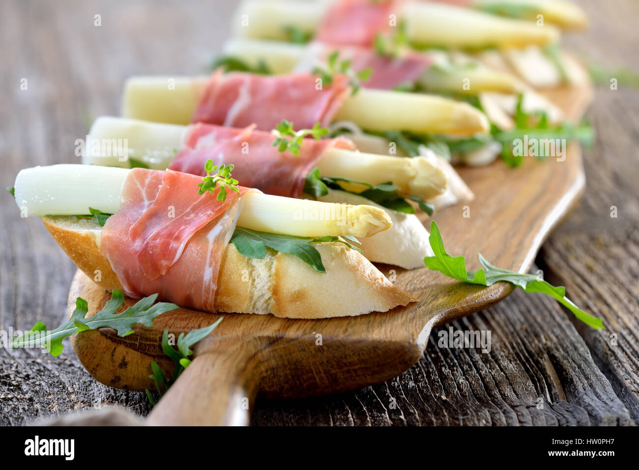 Köstliche Häppchen mit weißen Spargel auf Rucola Blätter eingewickelt mit italienischen Schinken Stockfoto