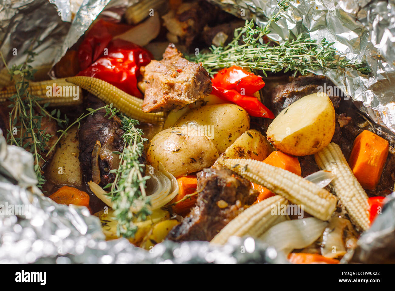 Gebratene Kartoffel mit Kräuter, Rosmarin, kleine Maiskolben. Stockfoto
