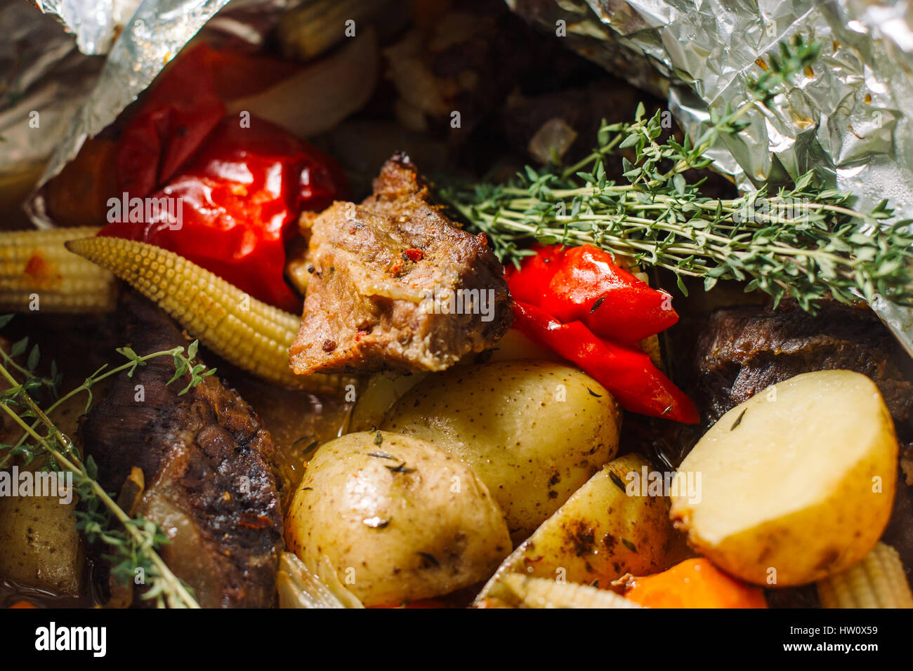 Gebratene Kartoffel mit Kräuter, Rosmarin, kleine Maiskolben. Stockfoto