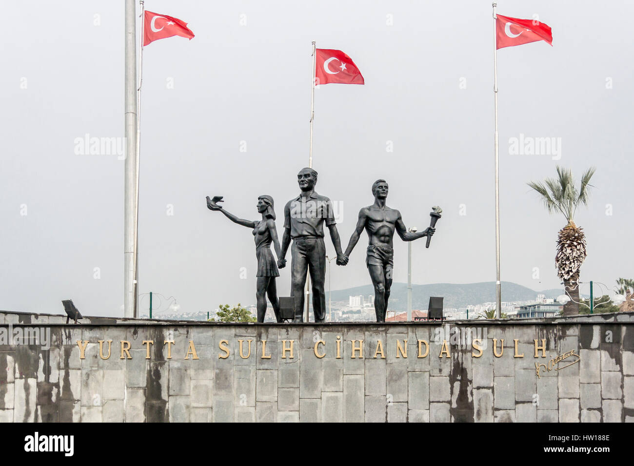 Denkmal von Atatürk und Jugend bedeutet Frieden und Hoffnung, Kusadasi, Türkei, Türkische Flaggen im Hintergrund. Übersetzung des Wortlauts: "Frieden in Hom Stockfoto