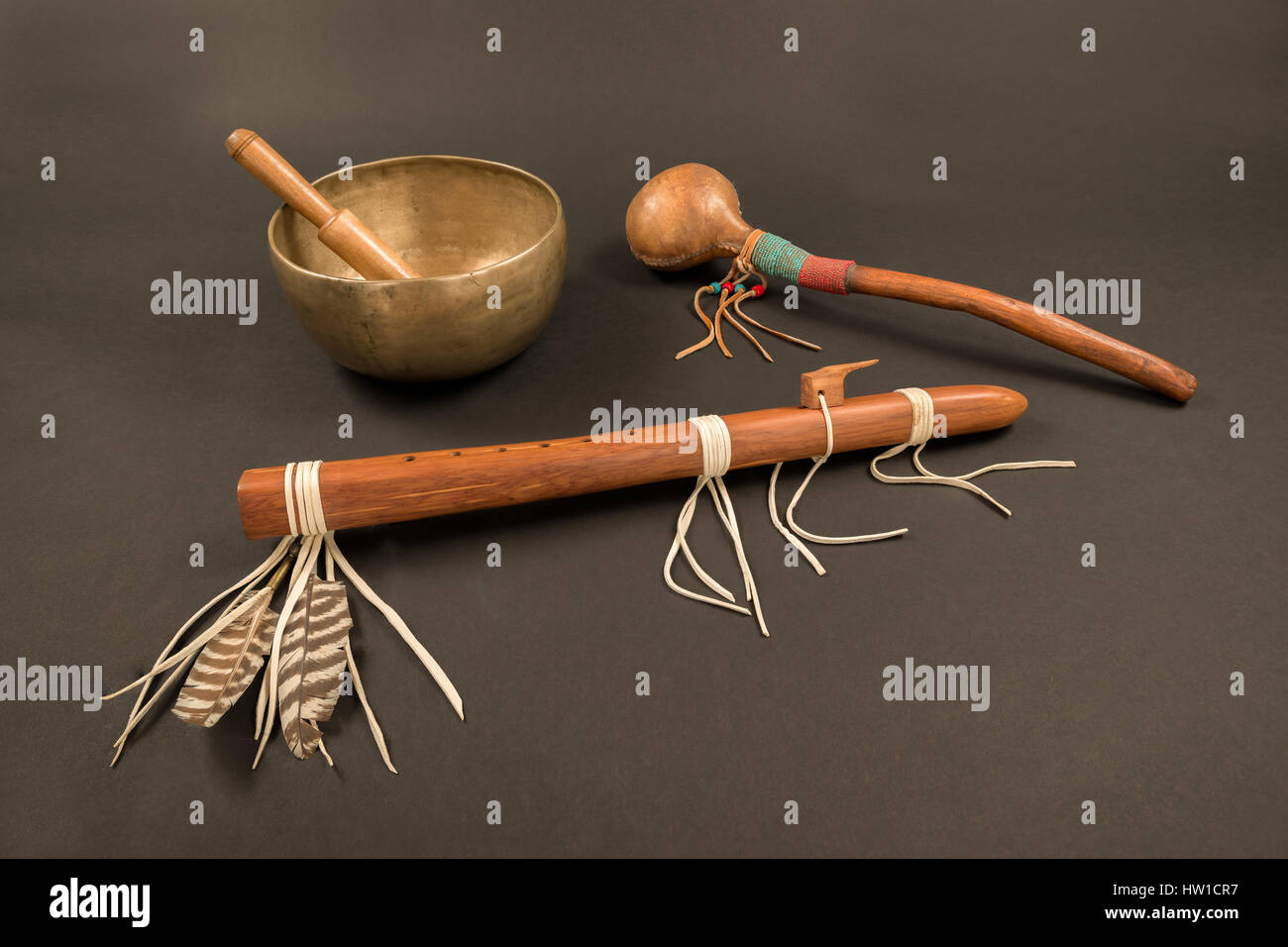 Native American flute mit Federn und perlen Shaker mit tibetischen Klangschalen und Klingeln. Stockfoto