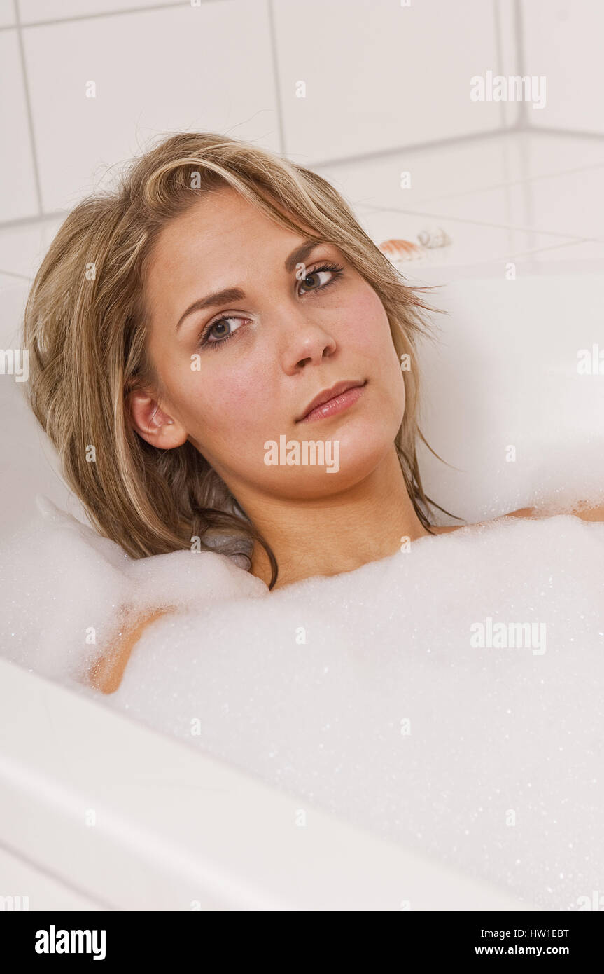 Attraktive Frau entspannt in der Badewanne, anziehend Frau Wohnhauses Sich in der finnische Stockfoto