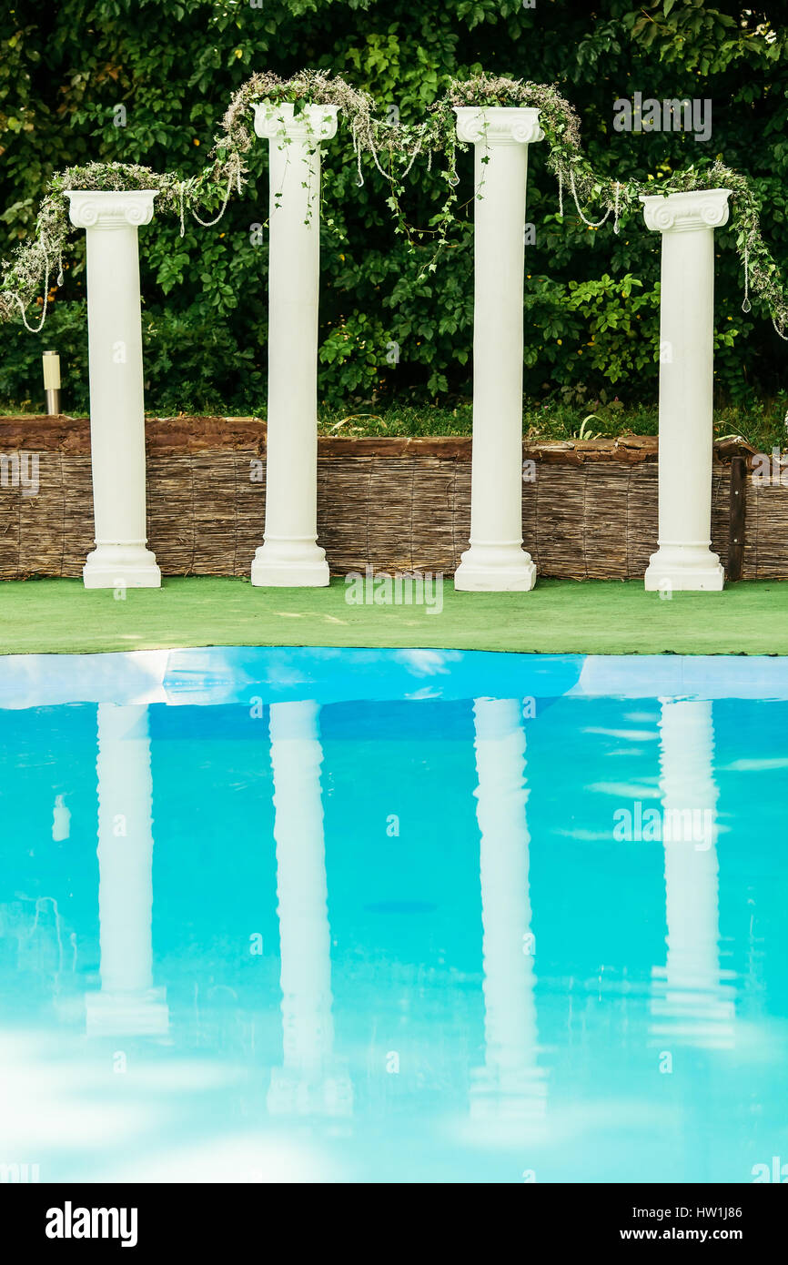 Dekorierte Säulen hinter türkisfarbenen pool Stockfoto