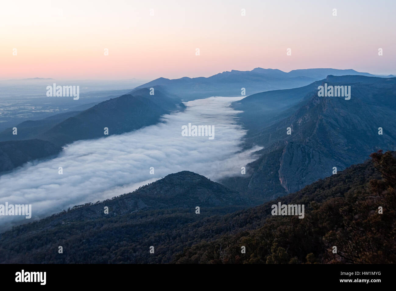 Wolken im Tal und der Wonderland Range bei Sonnenaufgang - vom Schnellboot Aussichtspunkt in den Grampians, Victoria, Australien Stockfoto