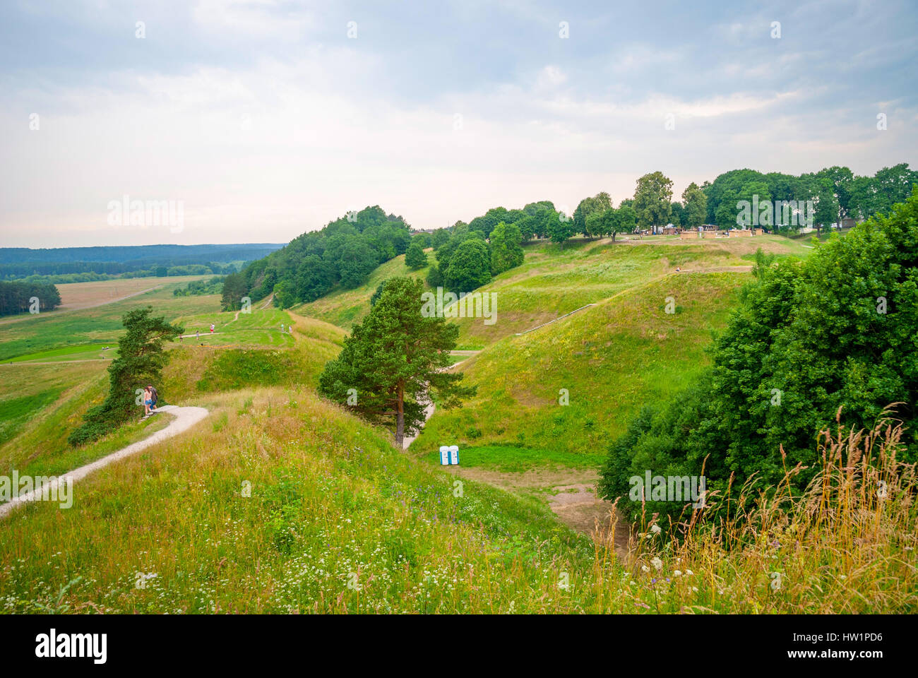 Blick auf unkenntlich Menschen wandern Wanderweg auf grünen Hügeln. Wallburgen im Kernave, alte Hauptstadt Litauens Stockfoto