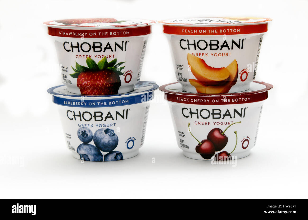 Vier Container von Chobani griechischer Joghurt verschiedener Aromen stehen gegen den weißen Hintergrund. Stockfoto