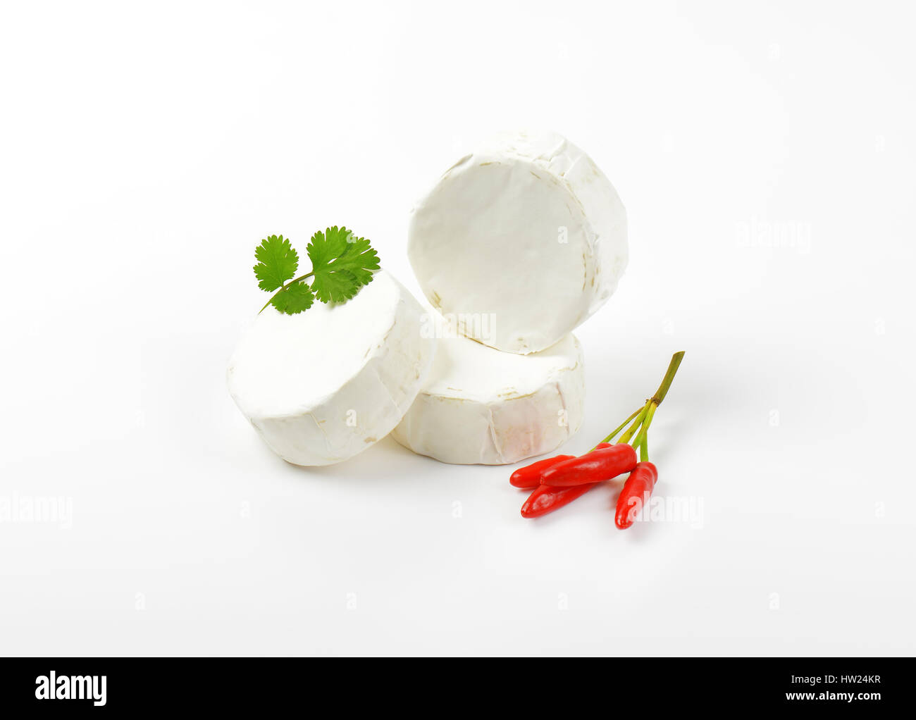 Räder von weißer Käse und rote Chilischoten Stockfoto