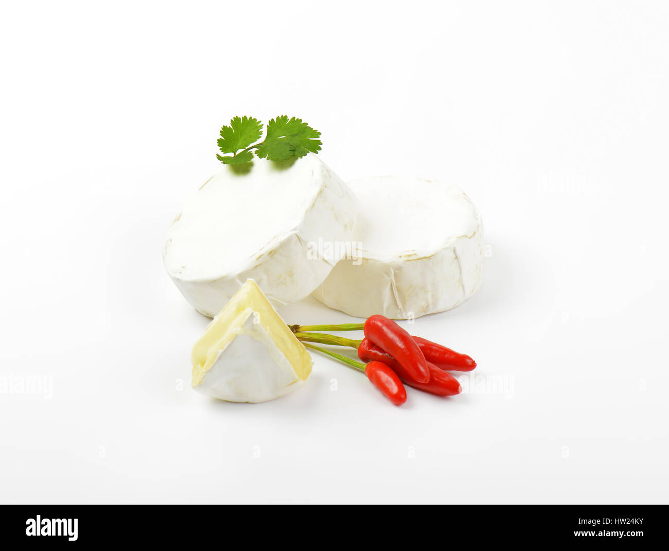 Räder von weißer Käse und rote Chilischoten Stockfoto