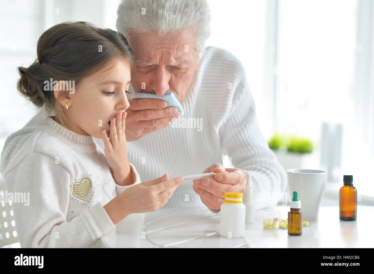 Enkelin kümmert sich um einen kranken Großvater Stockfoto