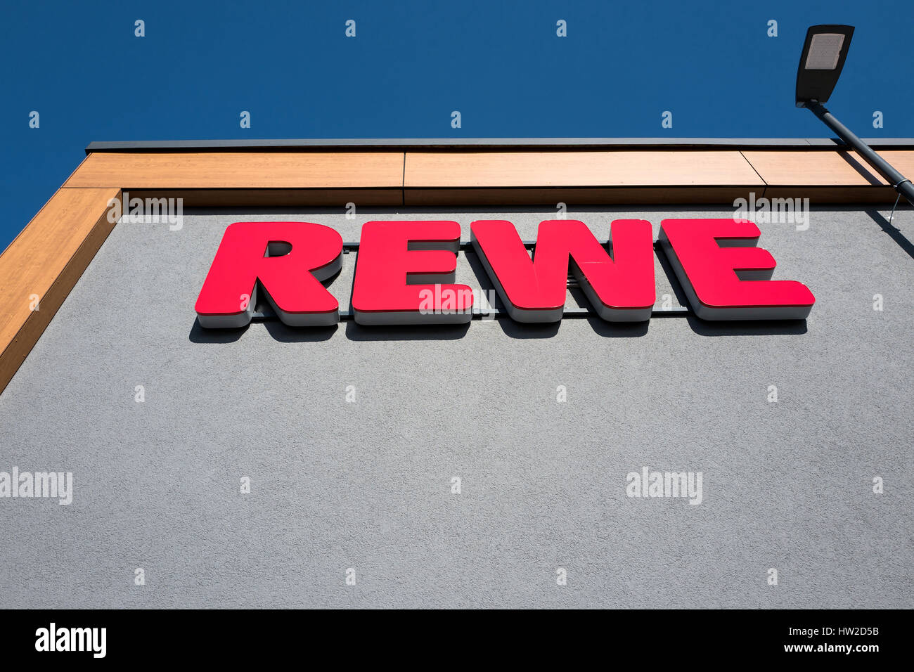 REWE-Schild am Zweig. REWE betreibt rund 3.300 Supermärkte in Deutschland. Stockfoto