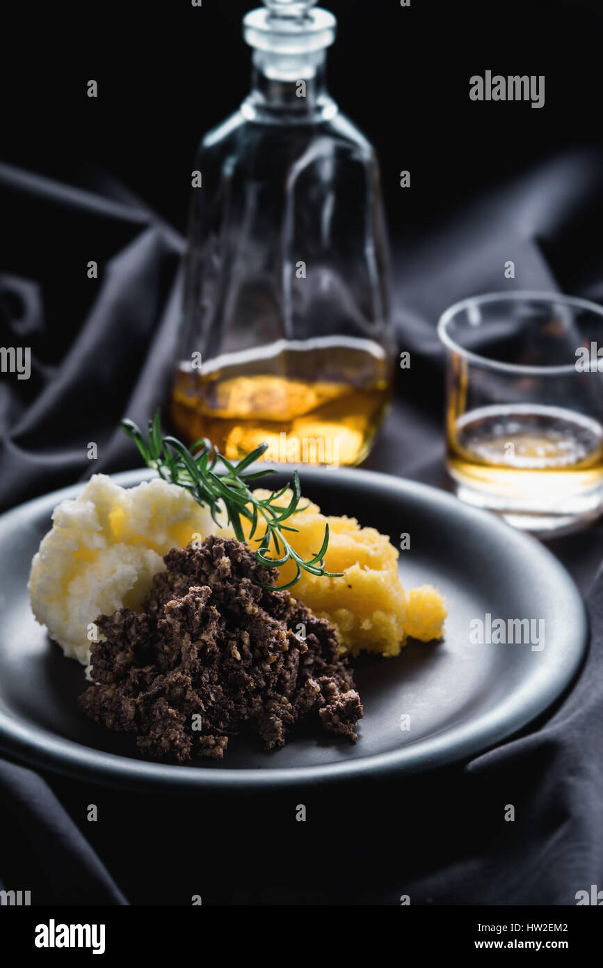 Haggis mit gestampften Rübe, Kartoffeln und Whisky. Stockfoto