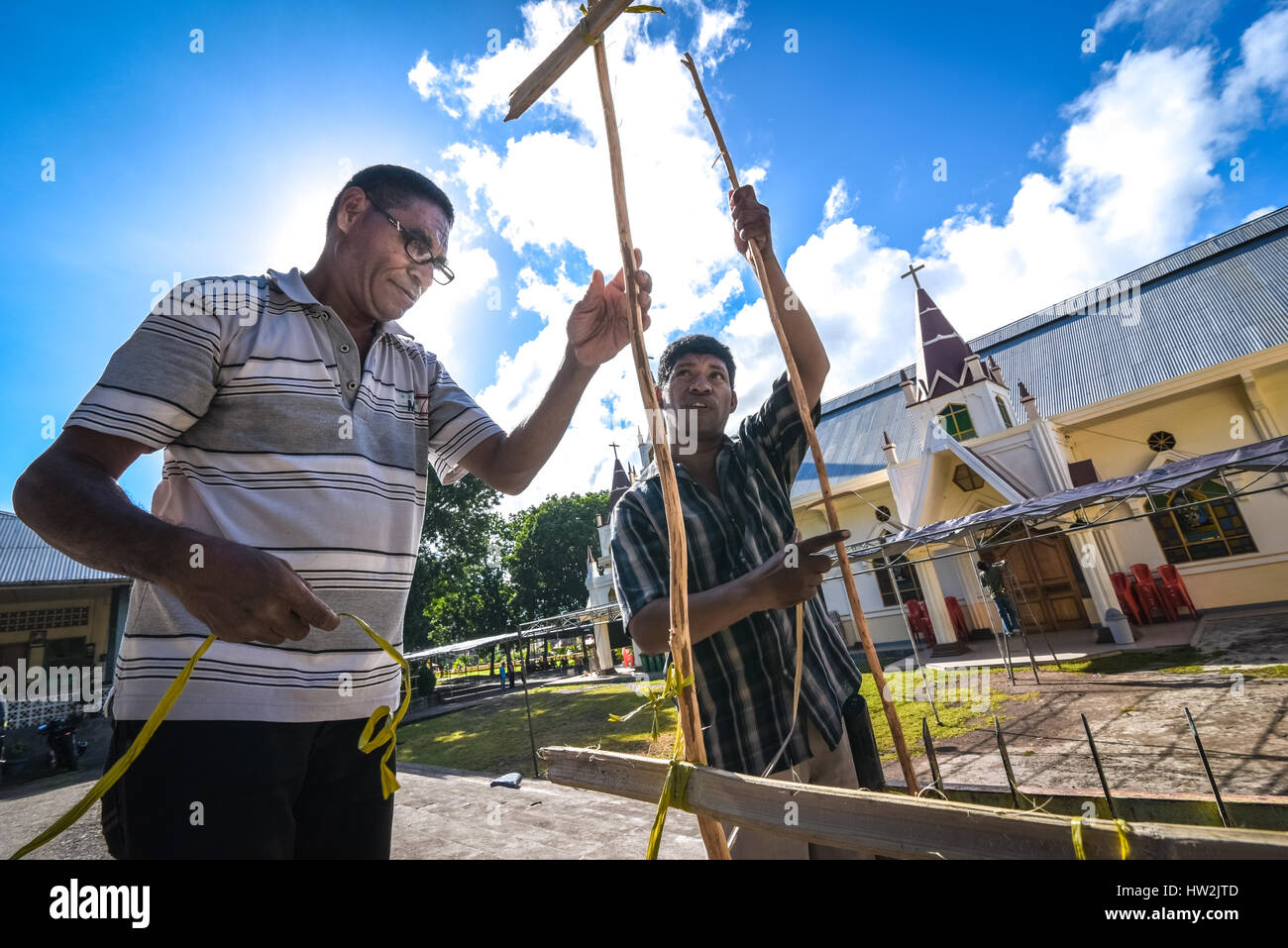 Menschen, die Bambuszäune bauen, um Kerzen entlang der Straße zu stellen, als Vorbereitung auf die Prozessionen der Heiligen Woche in Larantuka, Ost-Nusa Tenggara, Indonesien. Stockfoto