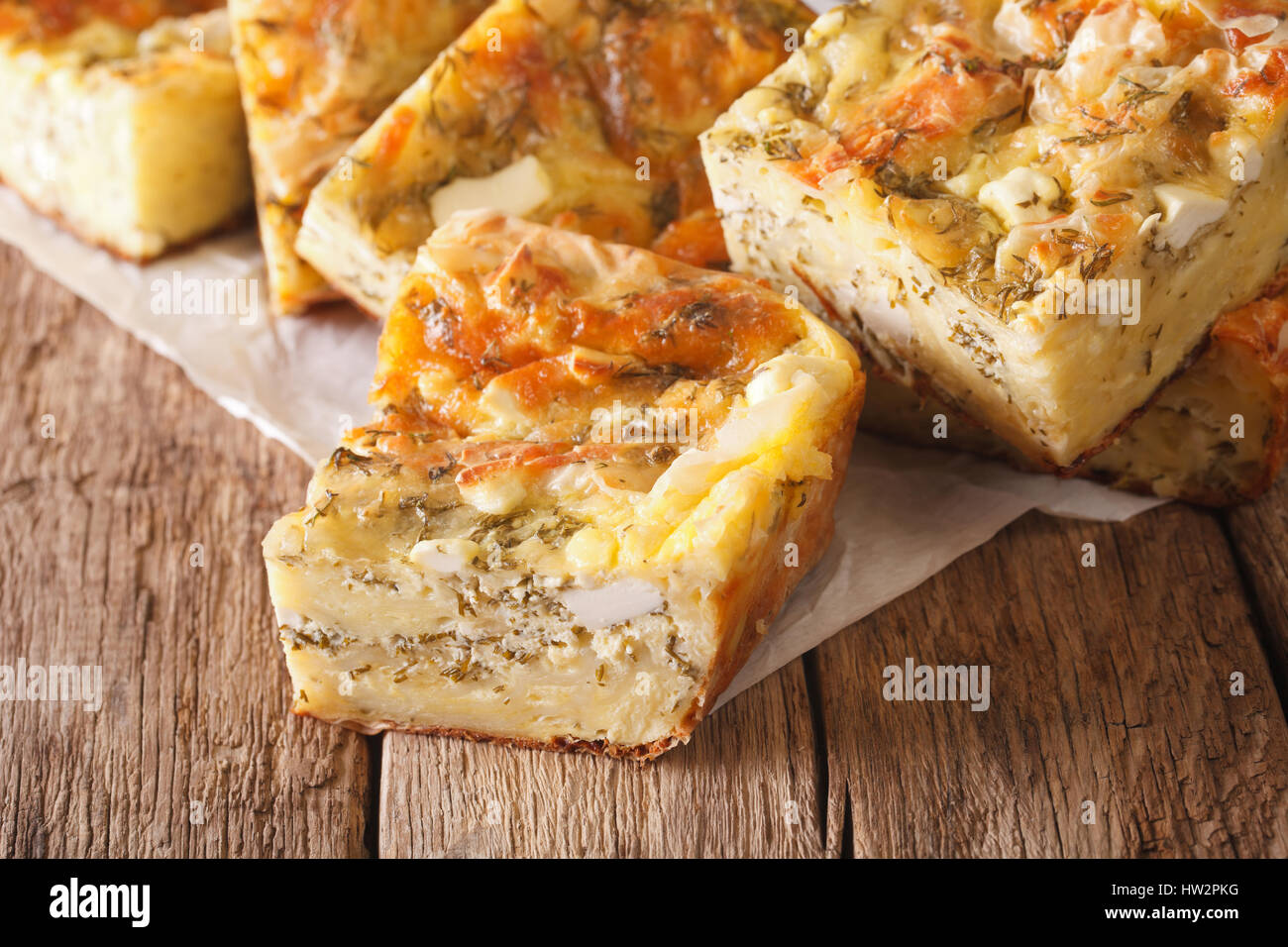 Serbische Küche: in Scheiben geschnitten Gibanica Kuchen mit Käse, Eiern und grünen Nahaufnahme auf dem Tisch. horizontale Stockfoto