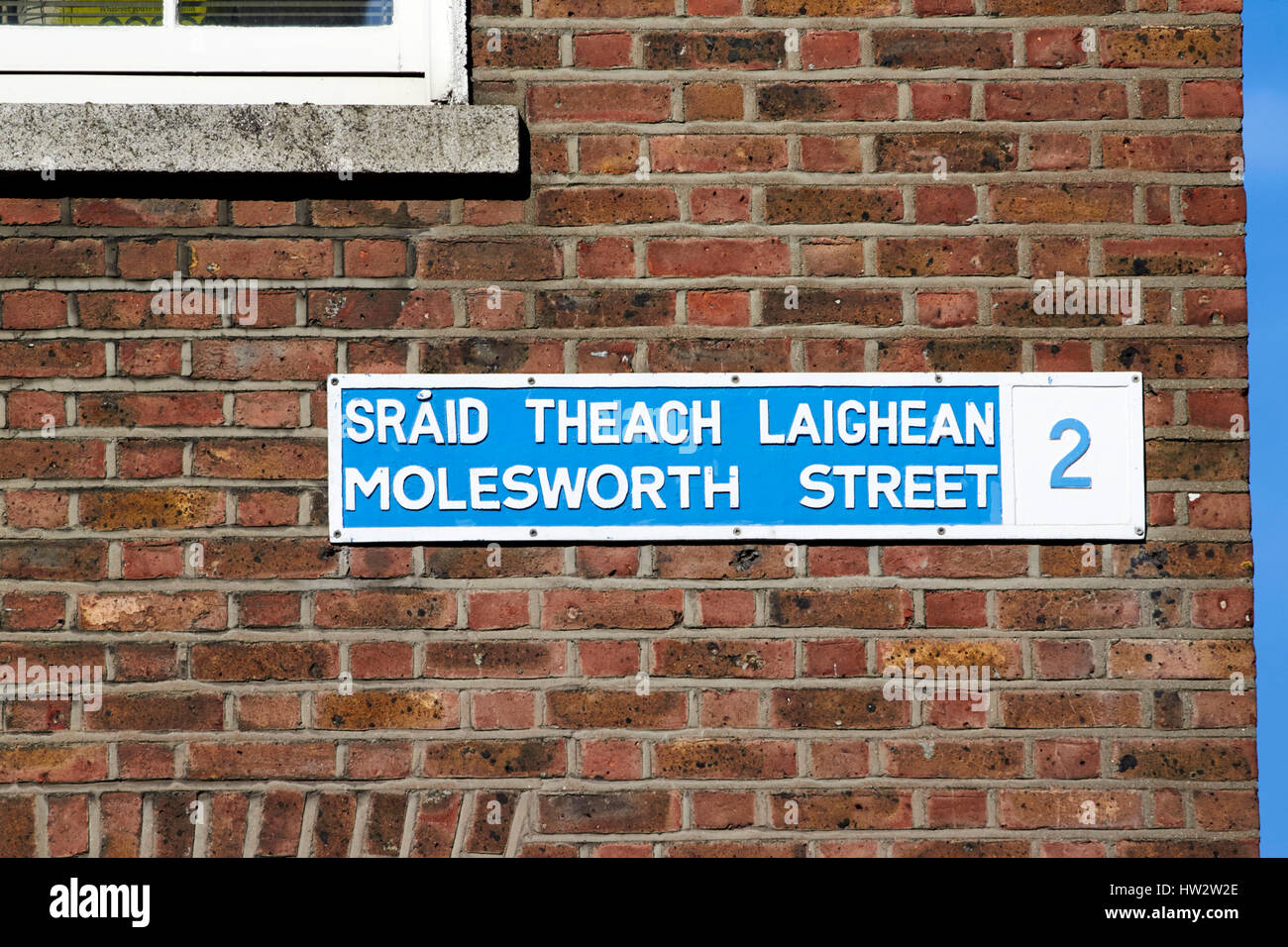 alten blauen und weißen zweisprachiges Straßenschild für Molesworth street auf rotem Backstein Mauer Dublin Irland Stockfoto