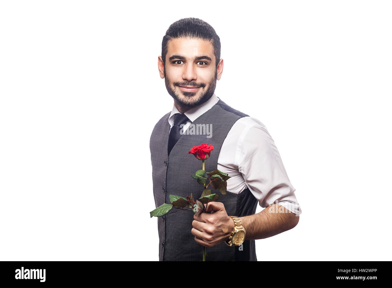 Schöne romantische glücklicher Mann mit Rosenblüte. Studio gedreht. isoliert auf weißem Hintergrund. halten und geben Blume und Blick in die Kamera und lächelnd. Stockfoto