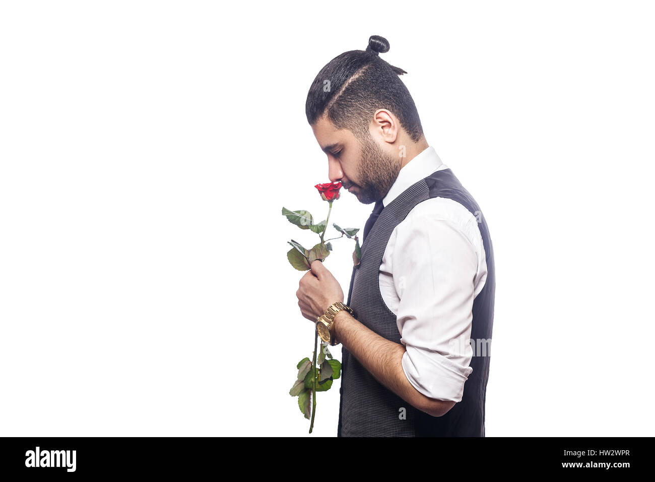 Schöne romantische glücklicher Mann mit Rosenblüte. Studio gedreht. isoliert auf weißem Hintergrund. Holding und riechende Blume mit positiven Emotionen. Stockfoto