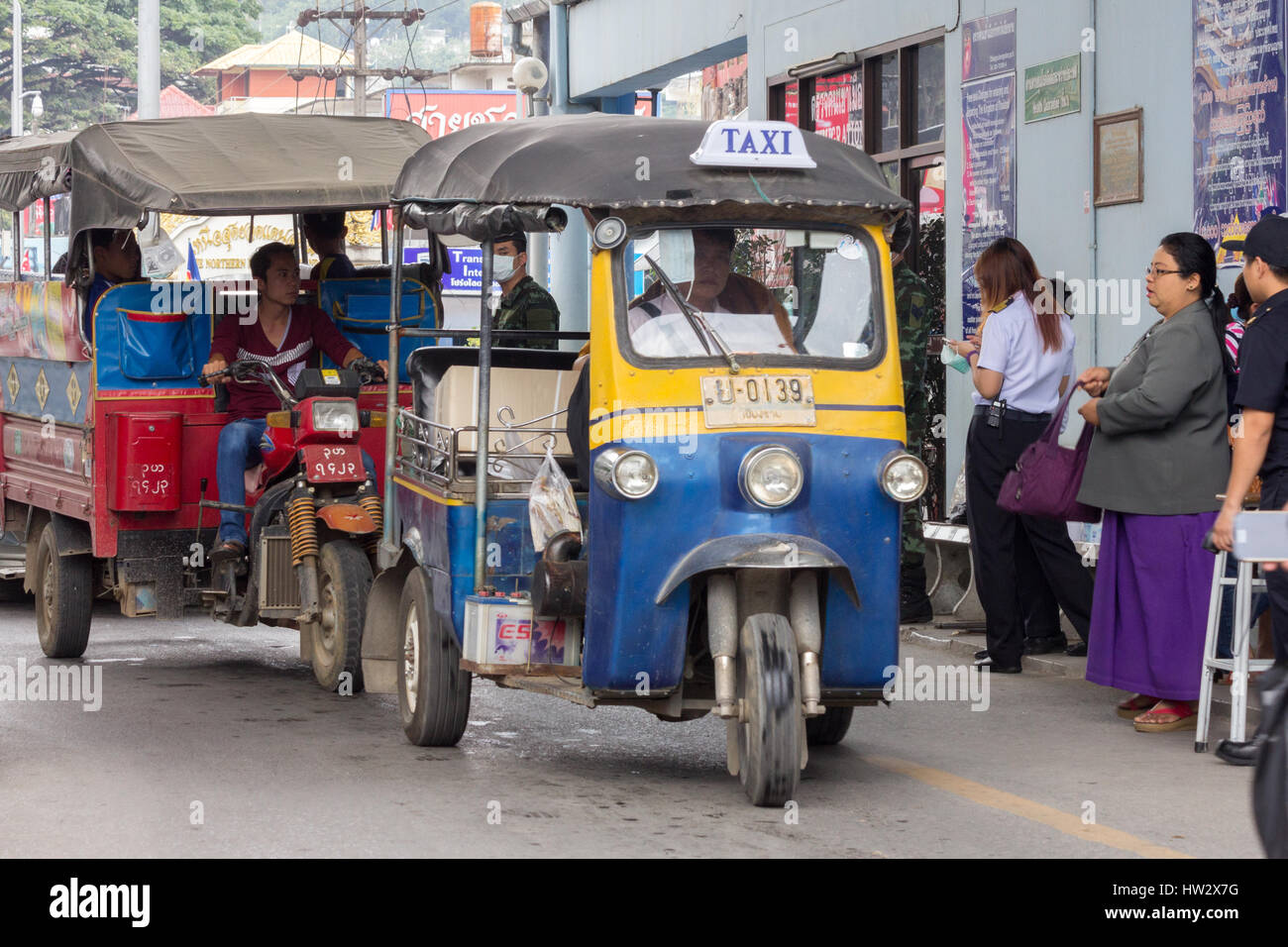 Ein Thai Tuk Tuk kreuzt wieder in Thailand aus Myanmar am Grenzübergang TheMae Sai, gefolgt von einem burmesischen Tuk tuk Stockfoto