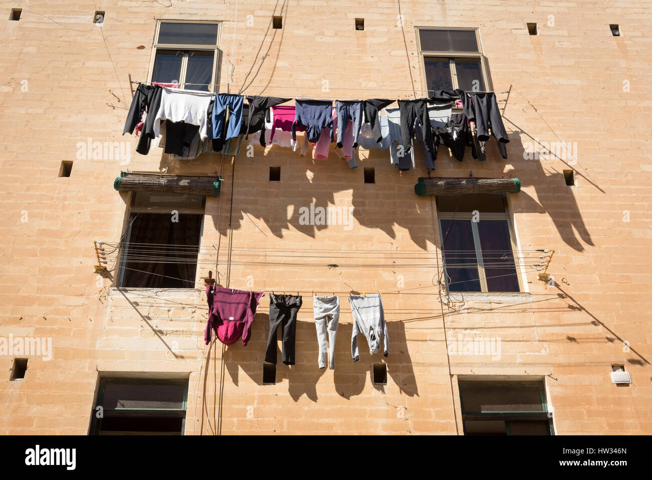 Reinigung und Wäsche hängen zum Trocknen auf Wäscheleinen auf ein altes Gebäude in Valletta Malta Stockfoto