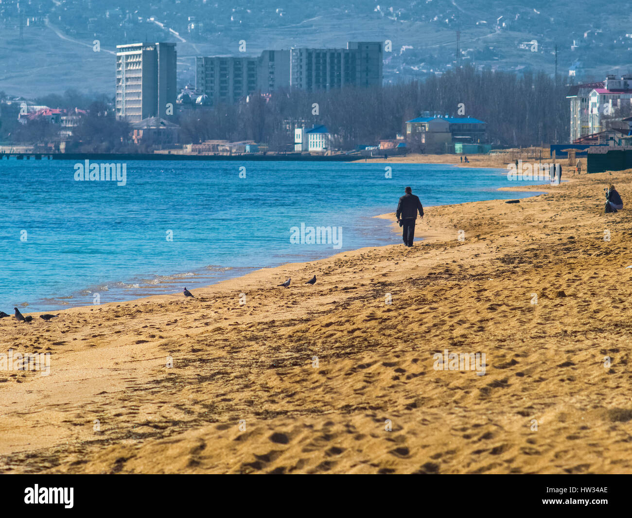 Der Strand, die Menschen und die Stadt am Horizont Stockfoto