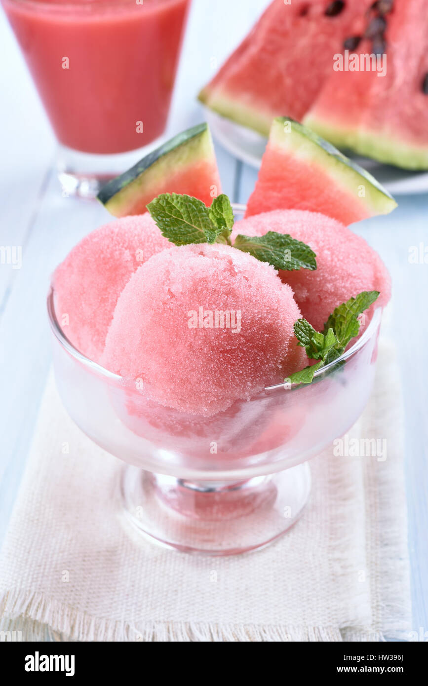 Wassermelone-Sorbet mit Minze und Scheiben in Glasschale, kalte Fruchtdessert dekoriert Stockfoto