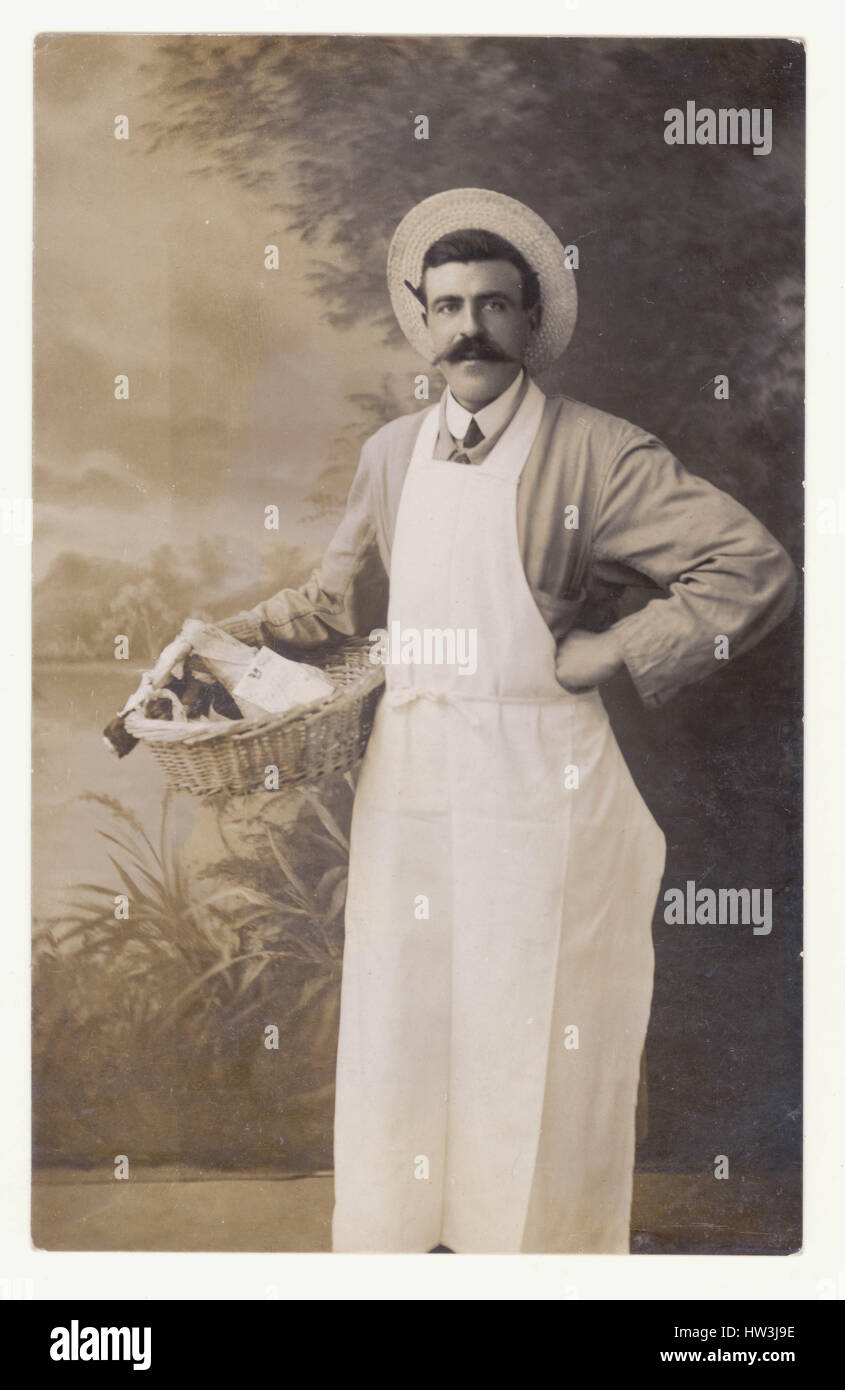 Edwardian Postkarte Lebensmittelhändler-Shop-Betreiber, Mitarbeiter oder Mitarbeiterin, seinen Korb mit Lebensmitteln, Studioportrait, U.K circa. 1910 Stockfoto